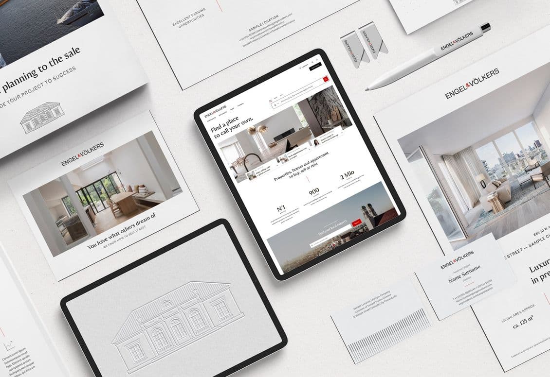 Marketingmaterialien für Immobilien, darunter Broschüren, Karten und ein Tablet mit einer Immobilienwebsite