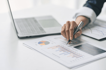 Laptop und Dokumente mit Diagrammen