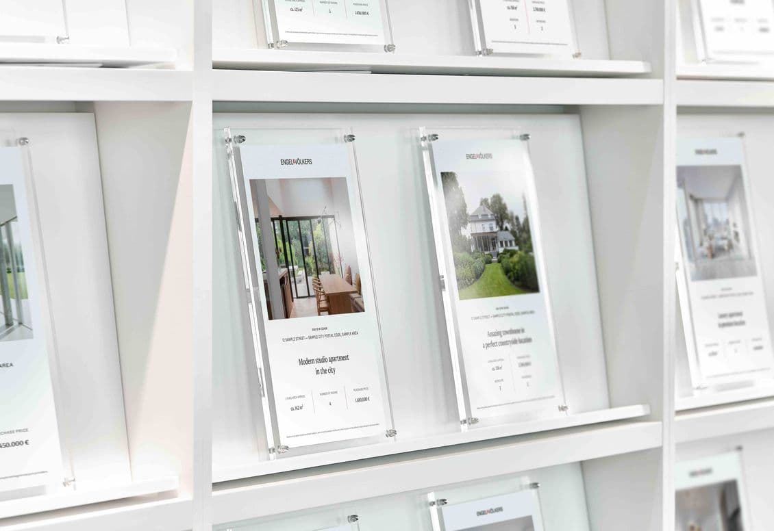 Immobilien-Exposés auf einem Regal